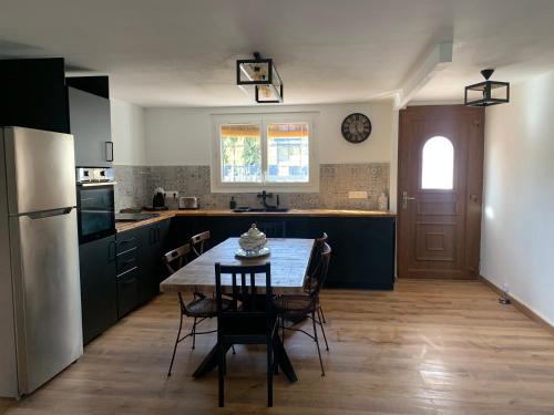 une cuisine avec une table, des chaises et un réfrigérateur dans l'établissement Maison 5mn de la mer, à Fréjus