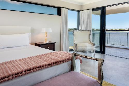 a bedroom with a bed and a view of the ocean at Water, views, vineyards, The Zen in Hermanus
