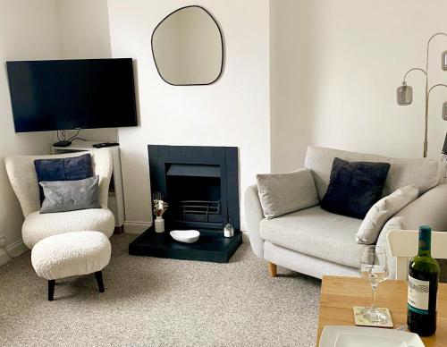 a living room with a couch and a fireplace at Bron Eryri - Our Cosy House opposite the entrance to Portmeirion! in Mynfford