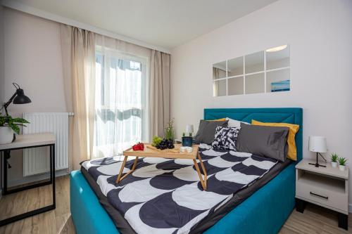 - une chambre avec un lit bleu et une table dans l'établissement GIL APARTMENTs 14, à Cracovie