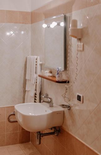 a bathroom with a sink and a mirror at San Raffaele Hotel Restaurant & Resort in Castelluccio Superiore