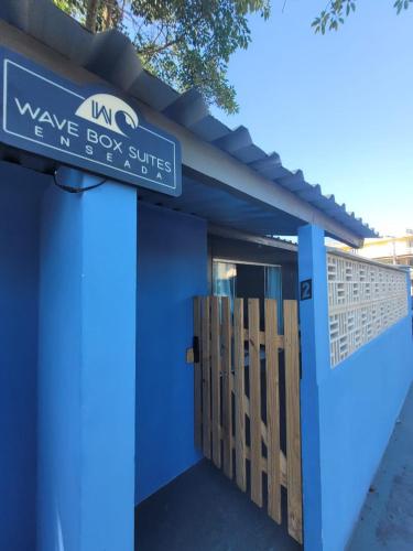 a blue building with a sign that reads wave boy suites at WaveBox Suítes Container in São Francisco do Sul