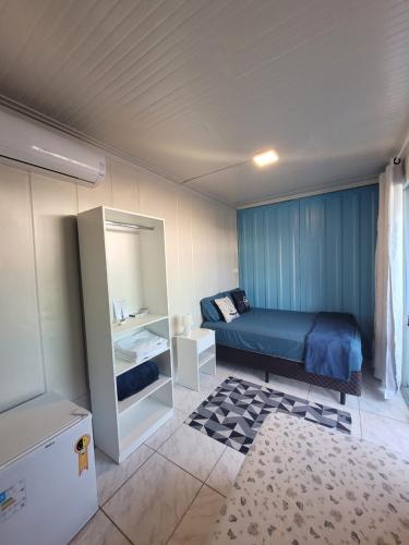 a small bedroom with a bed and a mirror at WaveBox Suítes Container in São Francisco do Sul