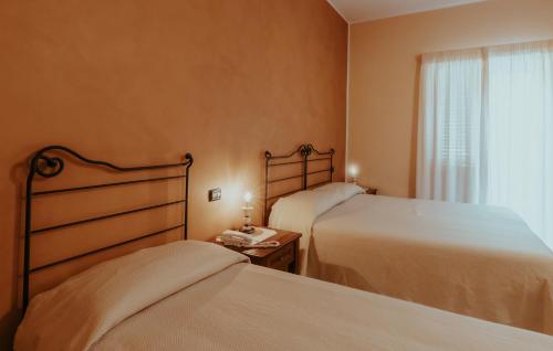 a bedroom with two beds and a window at San Raffaele Hotel Restaurant & Resort in Castelluccio Superiore