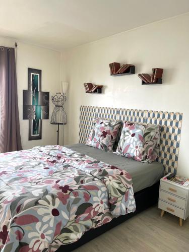 une chambre avec un lit avec une couette fleurie dans l'établissement PARIS centre ville lumière Tour Eiffel, à Paris