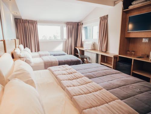 a hotel room with two beds and a television at Hotel EcoSki by bund in San Carlos de Bariloche