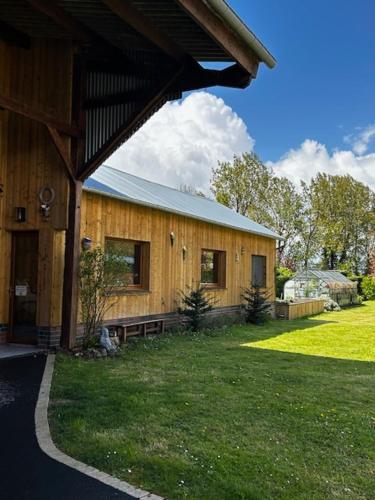 une maison en bois avec une cour herbeuse à côté dans l'établissement le 438 baie de somme bis, à Chépy