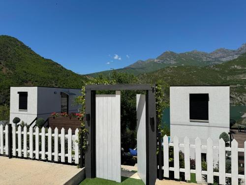 a white picket fence with a white gate at Koman Paradise by Romina in Shkodër