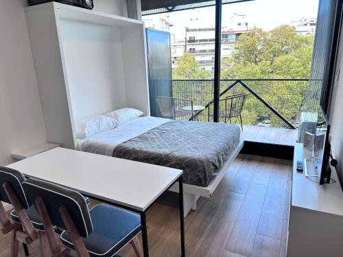 Habitación pequeña con cama y balcón. en Apart Lola en Buenos Aires