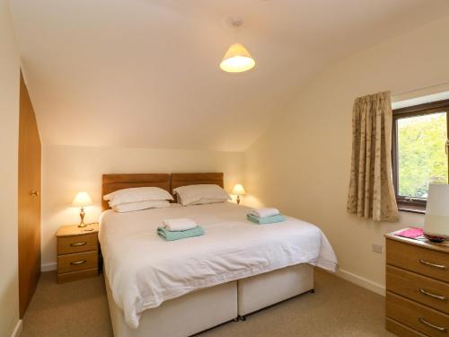 ein Schlafzimmer mit einem Bett und zwei Lampen und einem Fenster in der Unterkunft Rowanberry Cottage in Grasmere