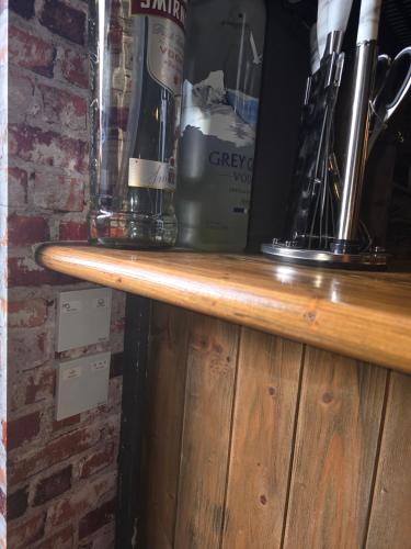 a wooden shelf with two bottles on top of it at The Pub - Unique & Authentic Experience - Free Parking!, 5 minutes from Airbus and The Mall Cribbs in Bristol