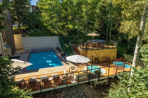 an overhead view of a swimming pool with tables and umbrellas at Top of the Village - CoralTree Residence Collection in Snowmass Village