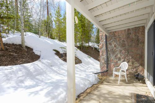 a white chair sitting on a porch in the snow at Hideaway Village Alpine 4 in Winter Park