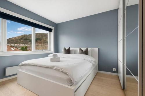 a bedroom with a white bed and a large window at Scandinavian Style Apartement! Balcony and Stunning Views! in Bergen