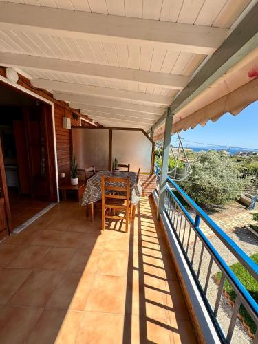a balcony of a house with a table and chairs at Guesthouse Rondo in Himare