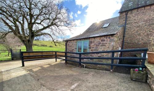 a black bench next to a brick building at Oaklands Cottage on a rural farm in Dingestow