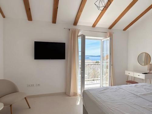 1 dormitorio con cama, TV y balcón en Luxury Villa Michelle, en Orebić