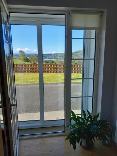 a sliding glass door with a view of a road at Lake View House in Garvagh