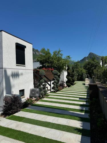 a long pathway with grass and a building at Koman Paradise by Romina in Shkodër