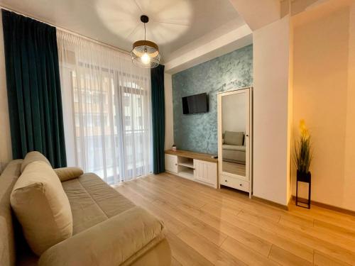 - un salon avec un canapé et un miroir dans l'établissement Seaside Apartments Mamaia Nord, à Mamaia Nord – Năvodari