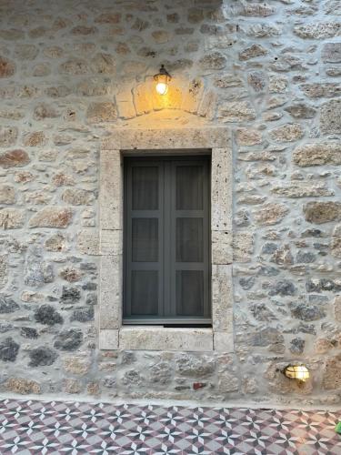 ein Fenster in einem Steingebäude mit Licht in der Unterkunft Porto Calino in Kalymnos
