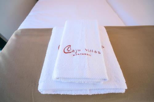 um par de toalhas brancas sentadas em cima de uma mesa em Caju Villas Montargil - Villa Pedra Furada em Montargil