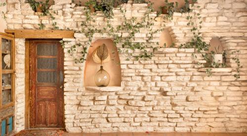 a brick wall with a vase on it next to a door at Hotel Casa Colibri in Playa del Carmen