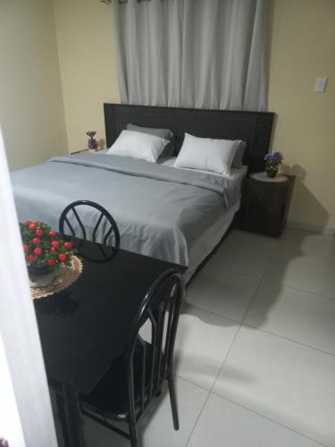 a bed with two pillows and a table with a chair at First derby Lodge in Benoni