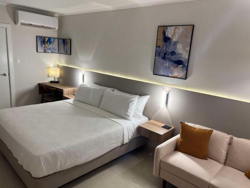 a bedroom with a white bed and a couch at Aruba Boutique & Art Hotel, BW Signature Collection in Palm-Eagle Beach