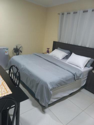 a large bed in a room with a table at First derby Lodge in Benoni