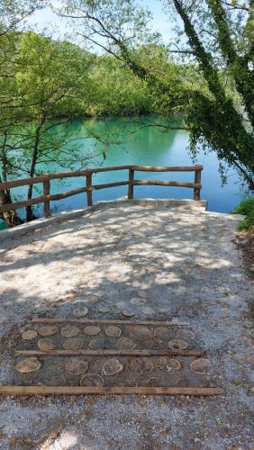 a wooden bench sitting next to a body of water at Unatime.Krupa in Bosanska Krupa