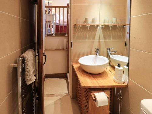 a bathroom with a white sink and a mirror at Beckside Studio in Patterdale