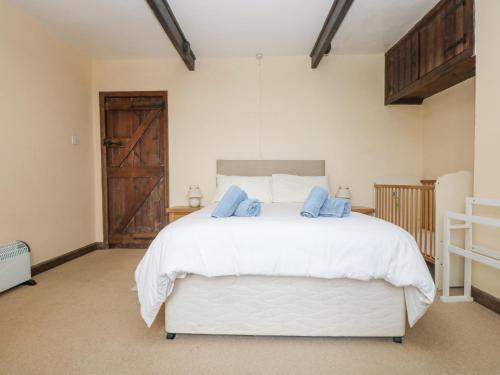 a bedroom with a large white bed with blue pillows at Parc An Castle Cottage in Lizard
