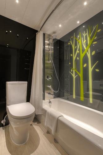 a bathroom with a toilet and a bath tub at Stanford Hillview Hotel Hong Kong in Hong Kong