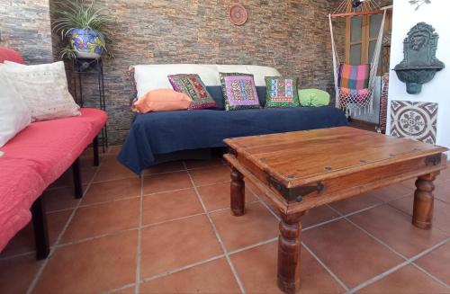 a couch with pillows and a table in a room at Hostal R-Conecta in Cuevas de San Marcos