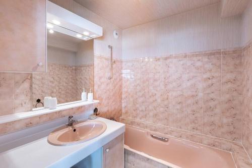 une salle de bain avec un lavabo et une baignoire dans l'établissement Appt spacieux FACE MER - 2 chambres - 6 personnes, à Pornichet