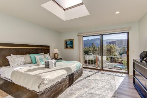 ein Schlafzimmer mit einem Bett und einem großen Fenster in der Unterkunft Sedona Bellissimo 180-degree Red Rock Views, private backyard oasis, hot tub & fresh air-Nature! in Sedona