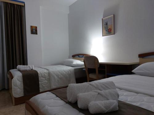 a hotel room with two beds and a desk at Wendy's Apartment in Berat