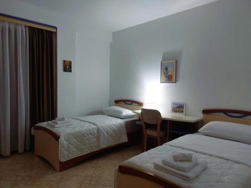 a hotel room with two beds and a desk at Wendy's Apartment in Berat