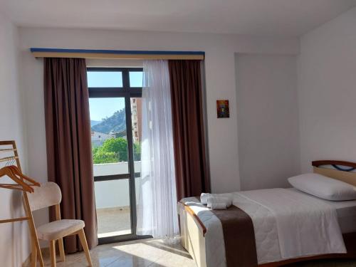 a bedroom with a bed and a sliding glass door at Wendy's Apartment in Berat