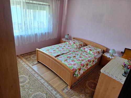 um pequeno quarto com uma cama e uma janela em Stefin kutak em Bosanski Novi