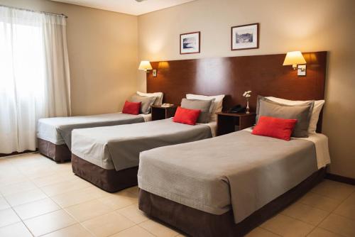 a hotel room with two beds with red pillows at DonSuites in Corrientes