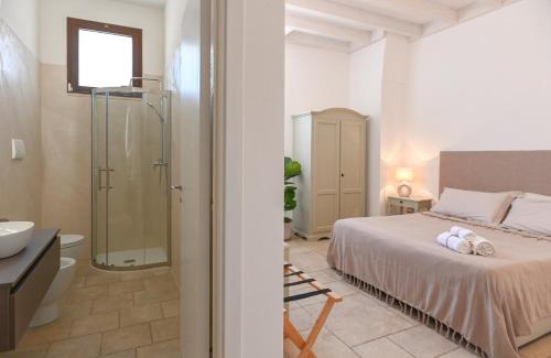 a bedroom with a bed and a bathroom with a shower at Mediterranea Residence in Nardò
