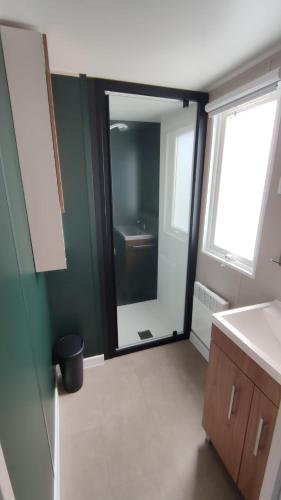 a bathroom with a sink and a mirror at MOBILHEIM HERZ LAUWERSOOG - Chalet Pampusplaat in Lauwersoog