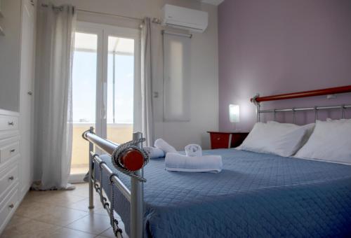a bedroom with a bed with a blue comforter at The Garden House in Aegina Town