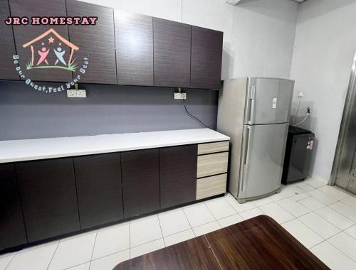 a kitchen with a refrigerator and a counter top at JRC Homestay DT21- (Desa Tebrau) in Johor Bahru