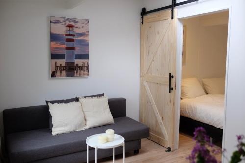 a room with a couch and a bed and a door at Beach Lodge 24 - Noordwijk aan Zee - met eigen tuin in Noordwijk