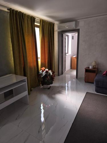 uma sala de estar com piso em mármore branco e uma sala de estar com um sofá em Terra Residence Beiuș em Beius