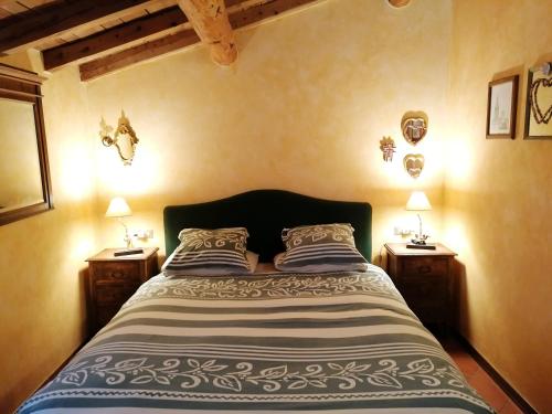 a bedroom with a large bed with two night stands at Mansarda Vista lago a Campodolcino in Campodolcino