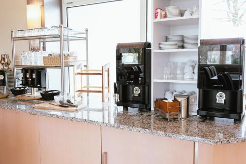 a kitchen with a counter with a coffee machine at Hotel am Park Bad Driburg in Bad Driburg